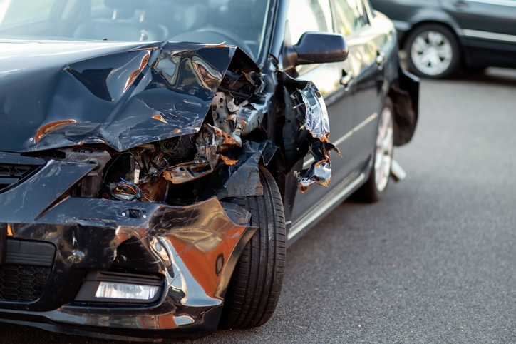 Close-up of damaged car part after accident showing broken metal and scratches